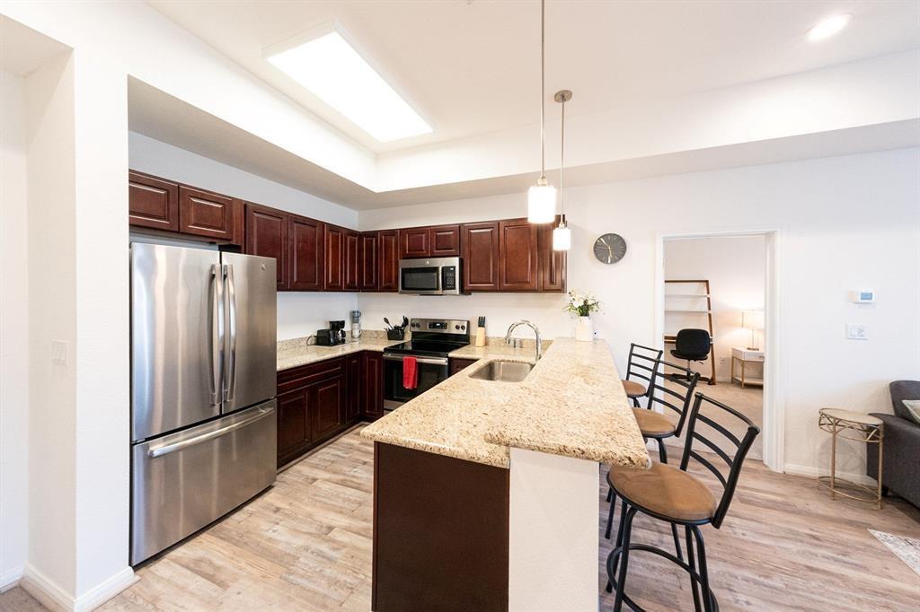 The Full kitchen has a stainless steel appliances and French door refrigerator. Also notice the built in microwave so no counter space is wasted, the granite countertop as well as the Electric cooktop.