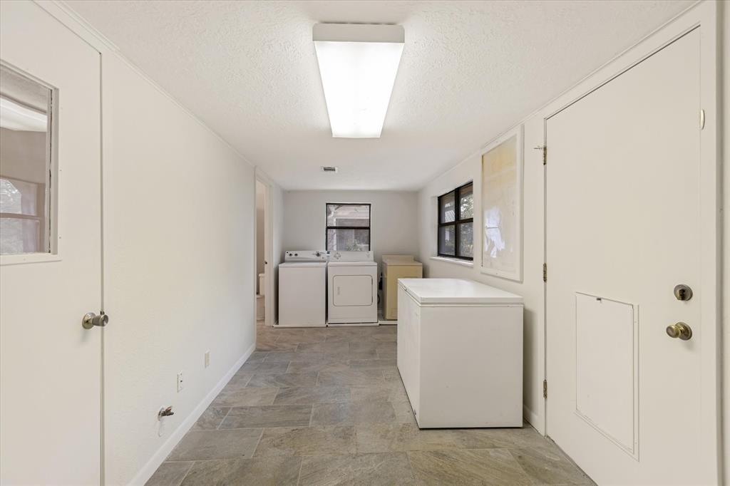 Laundry room at back of guest home with lots of space for storage and more .