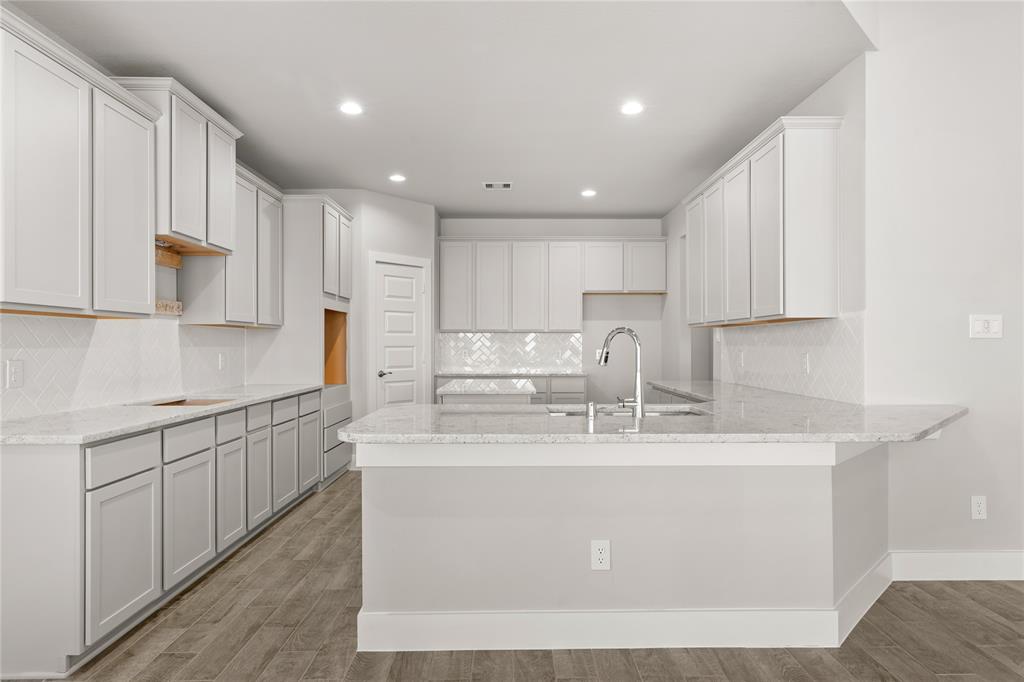 This kitchen is by far any chef’s dream! This spacious kitchen features white stained wood cabinets, granite countertops, SS appliances, modern tile backsplash, recessed lighting extended counter space, double sink and space for breakfast bar, and a walk-in pantry all overlooking your huge family room!