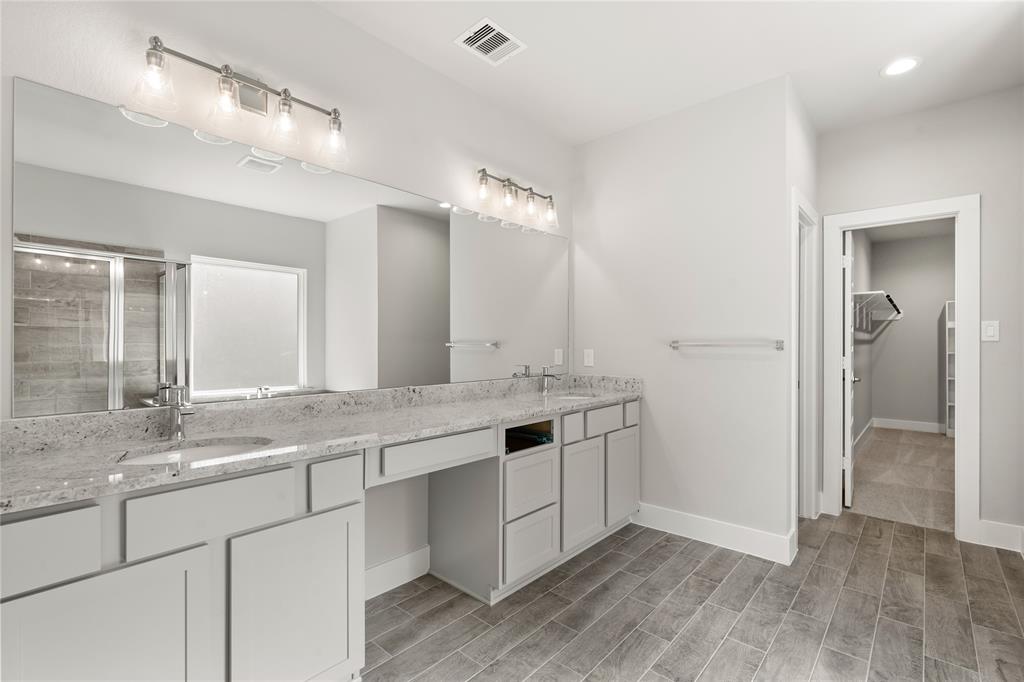 This large master bath is spacious enough to share! With separate vanities, large closet space, plentiful cabinet and counter space, you are sure to have private area while sharing this bathroom!