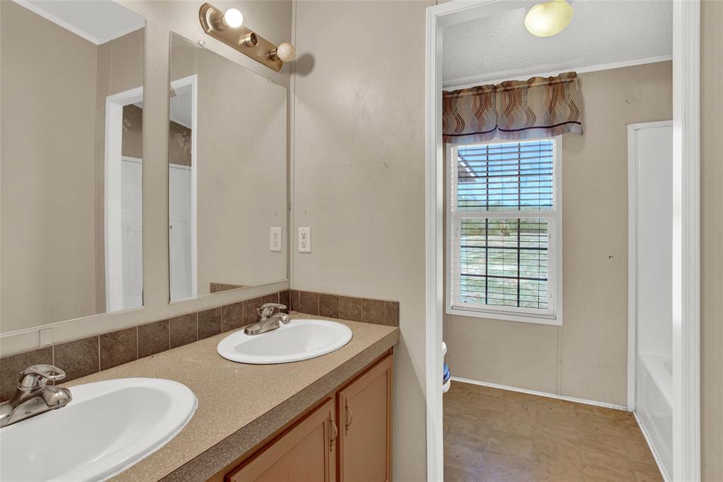 Secondary bathroom with double sinks and tub/shower combo.