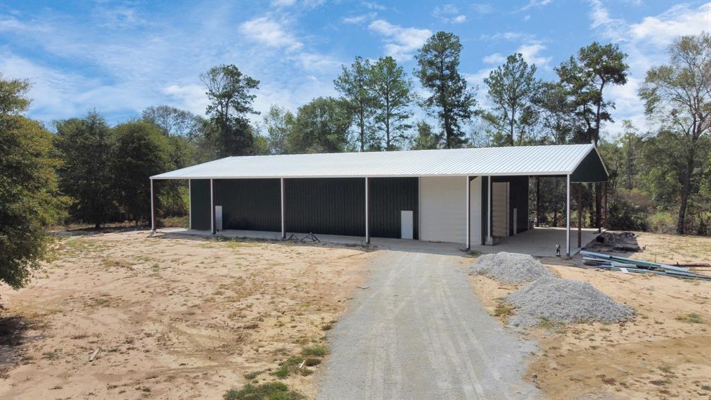 Gorgeous 11.974 acre property with huge new 40x100 metal shop or start to a massive barndominium on 60x100 concrete slab. Stocked 1 acre pond that was recently restructured. Mostly cleared with lots of mature trees around the property. Completely fenced, deep water well, RV sewer hookups, propane, and electric pole. Gravel roads placed and new entrance gate/fence. Easy access to FM2090/242/1485. Lots of development and commercial growth in the area. Country living with shopping and restaurants near by. Existing survey available, if new one is needed at buyers expense. Hablamos Español