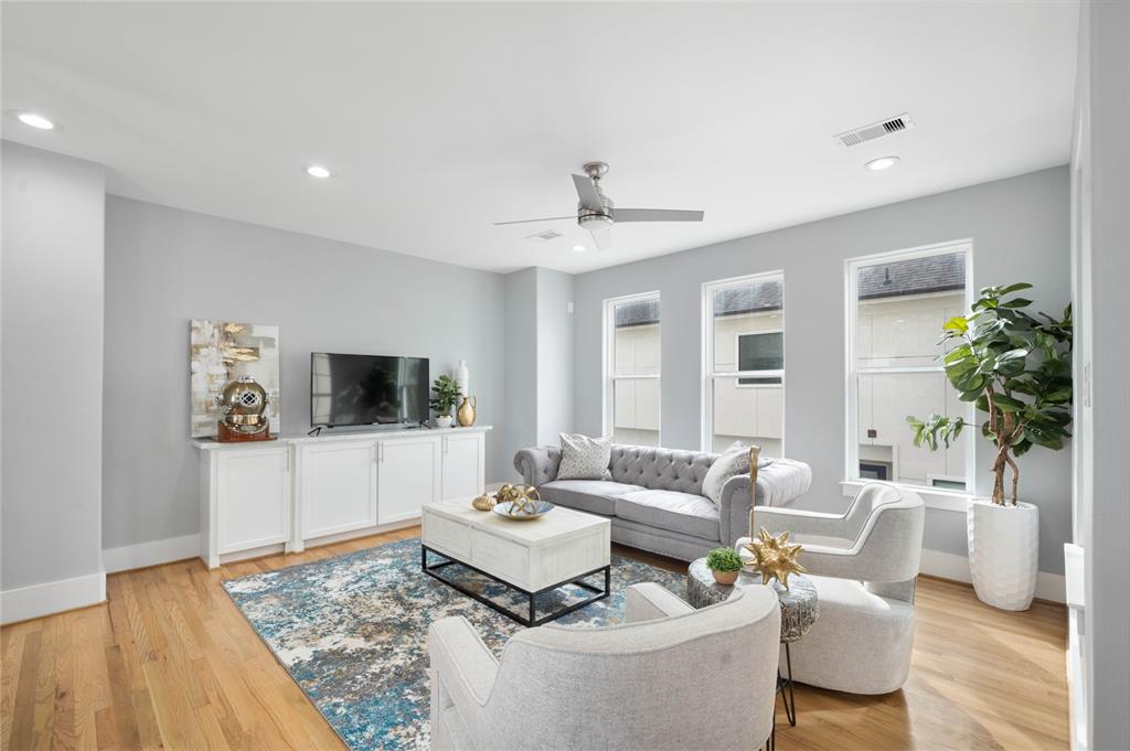 Memorable gatherings await in the open-concept living area with soaring ceilings, large windows, and ample space for an entertainment center and additional cabinetry.