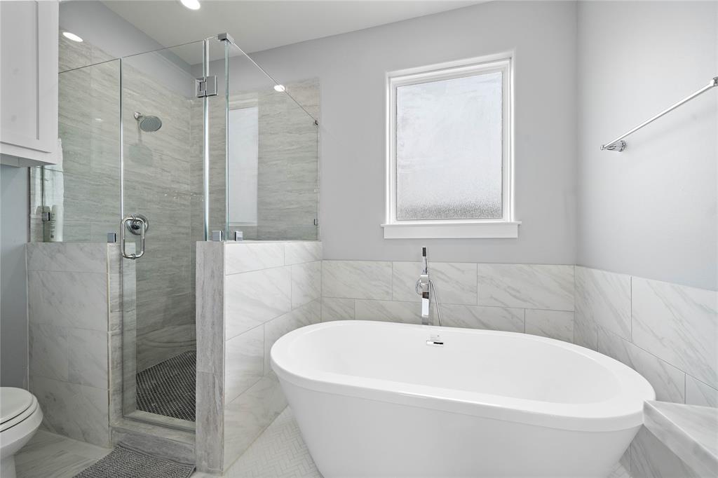 Relish a spa-like experience in the chic soaking tub or the walk-in shower adorned with mosaic tile floors and glass surround.