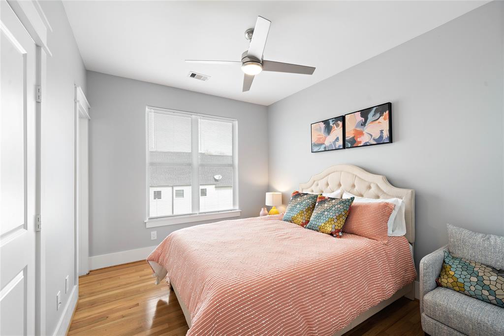 Easily convertible into a guest suite, this secondary bedroom features hardwood floors, its own ensuite bath, and large windows with scenic views of the community.