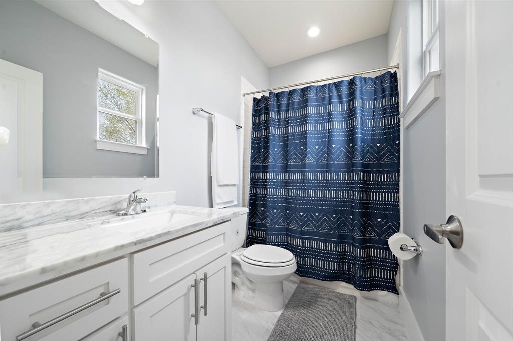 This secondary ensuite bath boasts tile floors, a spacious vanity area, plus an alcove tub and shower.