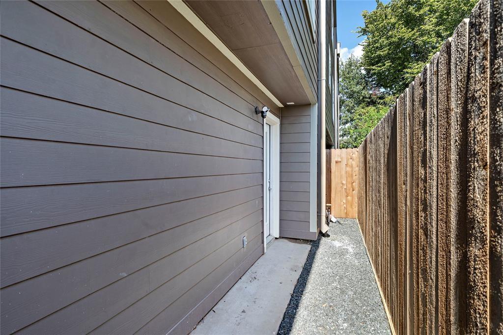 The private backyard showcases wood fencing, gravel landscaping, and ample outdoor space for a mini garden.