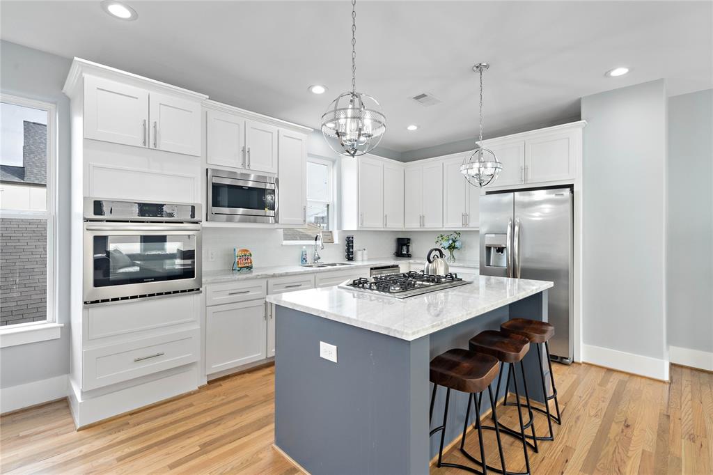 Showcasing the ideal blend of form and function, the kitchen comes complete with designer fixtures, lavish marble counters, and an abundance of built-ins for clutter-free storage.