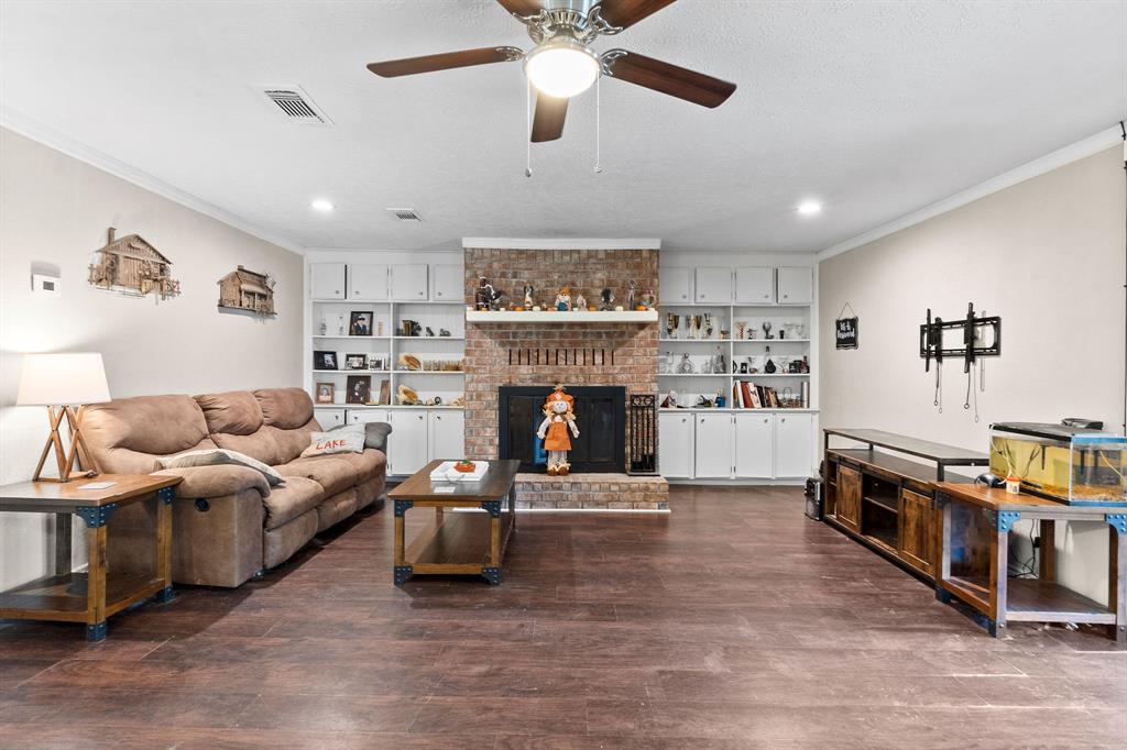 Wood burning fireplace surrounded by built in cabinets and shelving