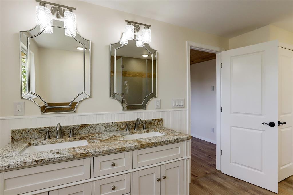 Double sinks and mirrors in the primary en-suite bathroom.