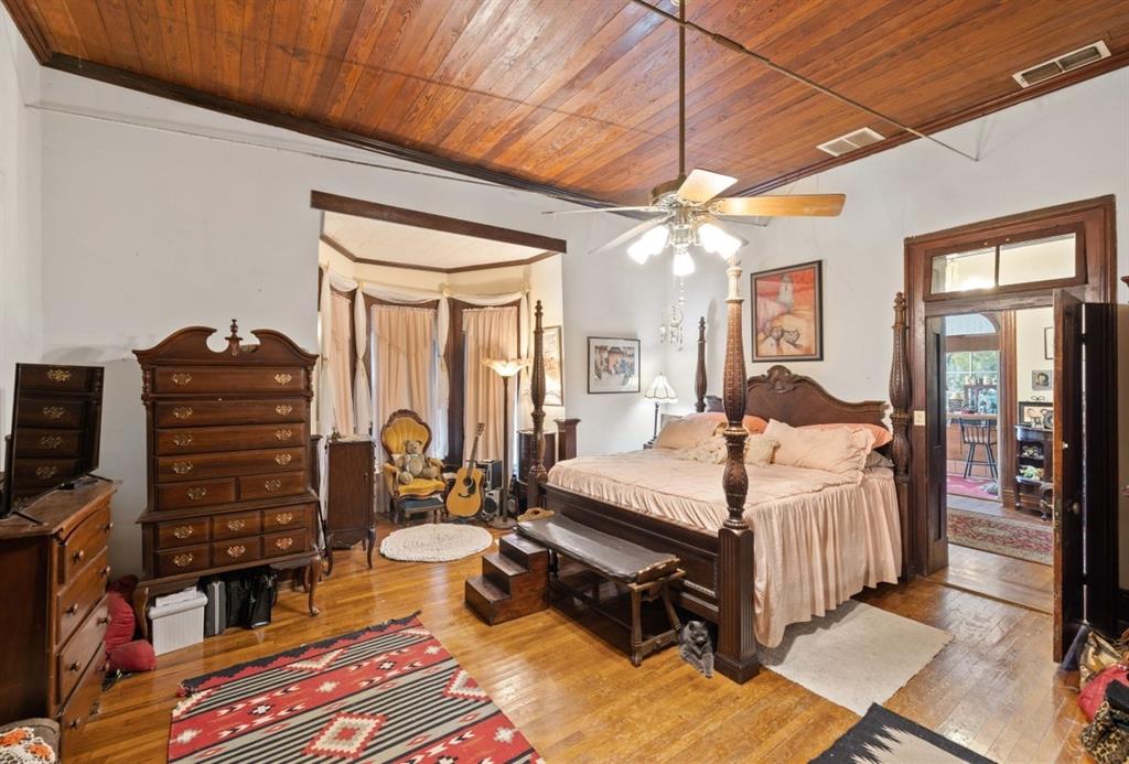 The large primary bedroom has a Bay Window sitting area. The view through the open door shows the foyer and the sunroom.