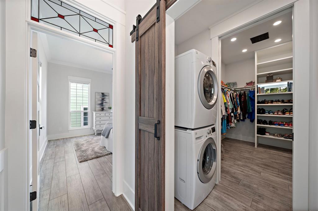 Conveniently accessible from the second-floor hallway and the primary walk-in closet, discover a utility/laundry room with a custom barn door and ample space for a dryer and washer.
