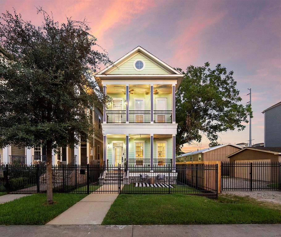Masterfully crafted, this custom-built home highlights a stunning curb appeal with a well-manicured lawn, wrought-iron fence railing, a second-floor balcony, and New Orleans-inspired architecture.