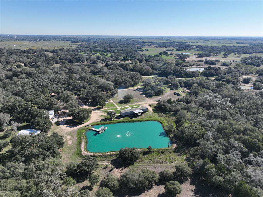 Beautiful unique turn-key diverse ranch with everything you need to enjoy hunting, fishing, & ranching, including the kitchen sink(s)!  Custom, insulated hunting blinds & game feeders are ready for this season.  ATV's, golf cart, & home furnishings convey (few exceptions – call for a list of items).  Plenty of room for all your family/friends/clients w/main home, ranch manger/guest home, cabin 1, cabin 2 & bunkhouse! Plenty of covered storage for your equipment/toys in the 24 X 40 pole barn, 20 X 20 carport, 20 X 20 shop, & 20 x 23 tool shed/cart charging area. PONDS w/fish feeders! 3 lg ponds w/piers for enjoying an afternoon of fishing-plus a frog pond/cool drink of water for all the wildlife. Miles of cleared trails for ATV's, paint ball course, shooting range, 20’ zip line over a pond, dense woods, open pastures, mature lives oaks, brush for habitat, fenced & X-fenced plus all the comforts of home in the well-maintained improvements.  This ranch is a must see!