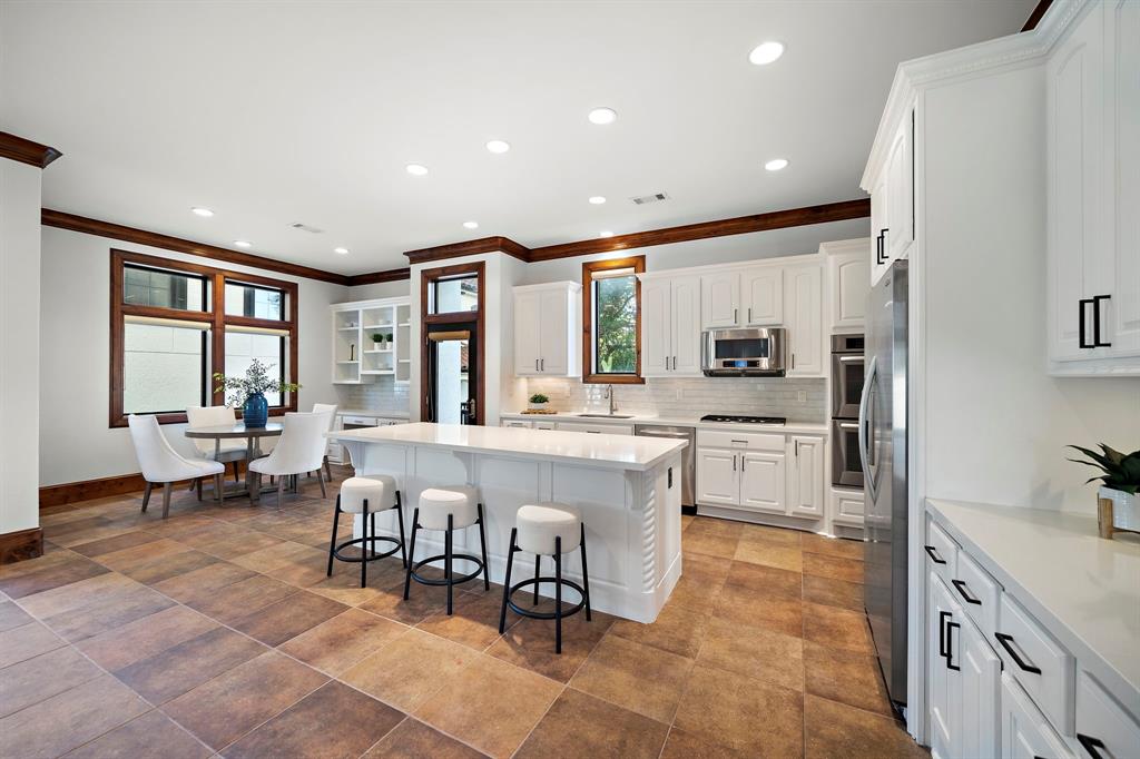 The gourmet kitchen strikes the ideal balance between form and function with quartz countertops, an expansive island, optimal storage space, and quick access to the breakfast area and outdoor deck.
