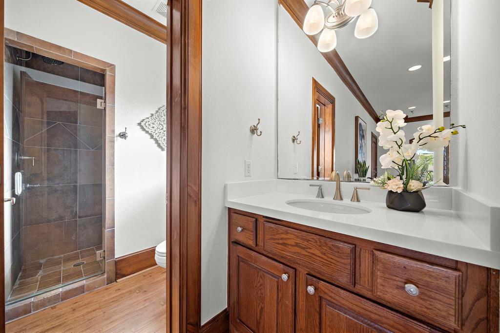 Stylish and functional, the casita's full bath features gleaming wood floors, a quartz vanity area, built-in storage, and a separate glass-enclosed shower.