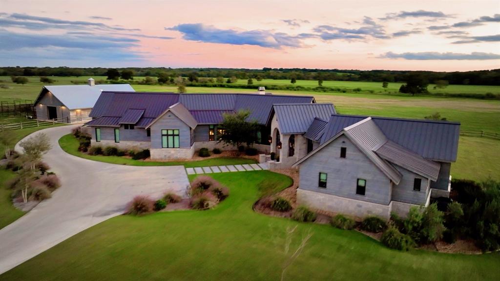 This stunning 5,500 square foot Neo-Rustic home sits on 265 acres. The home was designed by the award winning Houston,  Robert Dame Design. Halfway to everywhere: Houston, San Antonio, Austin, and Round Top. Also, in close proximity to three elite golf courses: The Falls , The Big Easy, and the area's newest course, The Darmor Club, set to open next spring. The land boasts a half mile of  Colorado River frontage.  There are also additional ponds, tanks, and a wooded creek that runs through the front portion of the property. This property has a current AG EXEMPTION and effortlessly supports our  current herd of  cattle along with horses. This 4 bedroom, 4.5 baths, 3 car garage, interior rockwork, wood floors, salvaged from a tobacco warehouse in Kentucky.  High vaulted ceilings, stone arches, double sided fireplace, spacious kitchen with high-end appliances and in addition there is upstairs guest quarters, outdoor patio with kitchen area and 2 large barns, in the same style of the home.