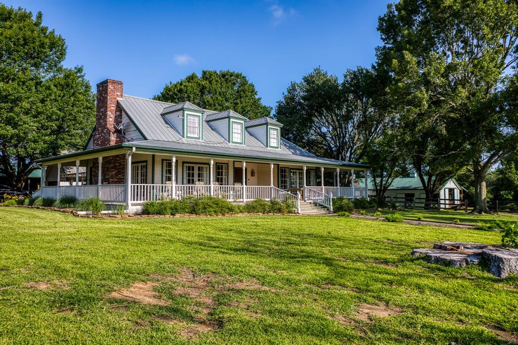 1712 Lynn Road Chappell Hill, Texas This 3/3 charming home sits among majestic oaks on 61.89 rolling acres. The original part of the house was the guest house for the Pennzoil family & boasts beautiful hardwood floors & rustic beamed ceilings. The LR & DR are great for entertaining w/a wood burning FP, cathedral ceilings & French doors that open to wrap around porches. Kitchen features granite countertops, stainless steel appliances, 2 ovens & brick paver flooring. Primary suite has French doors that open to the porch & primary bath includes a walk-thru shower, his & her sinks, a claw foot tub & huge walk-in closet. The add'l bdrm downstairs has porch access & the upstairs bdrm has a private bath & sitting area. The 1700sf, 2/2 guest house has a large living area & full kitchen. Amenities: Horse barn w/office & living quarters, workshop, round pen, dog kennels, chicken coup, irrigation system, 9 fenced pastures, 3 wells, a small cemetery, pond & wet weather creek. Both barns could be converted to beautiful event venues!