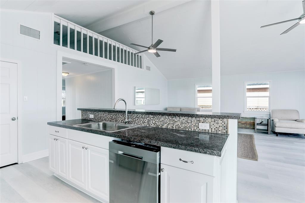 THIS KITCHEN FEATURES GORGEOUS GRANITE COUNTERS AND CUSTOM BACKSPLASH.