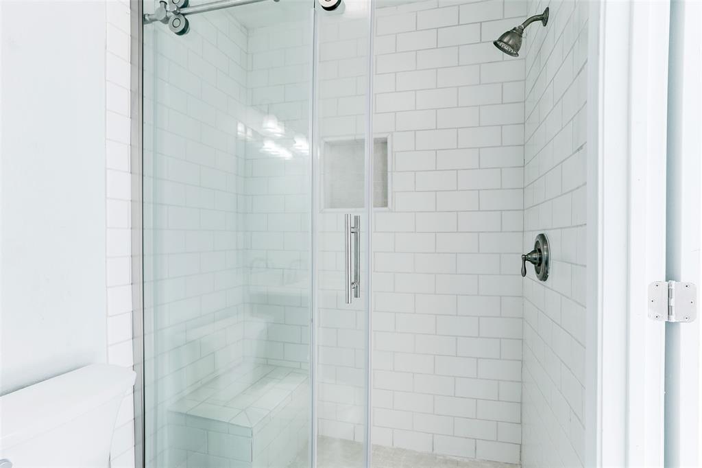 BATHROOM 2 OFFERS A RELAXING WALK-IN SHOWER (WITH BENCH) WITH FLOOR-TO-CEILING SUBWAY TILES.