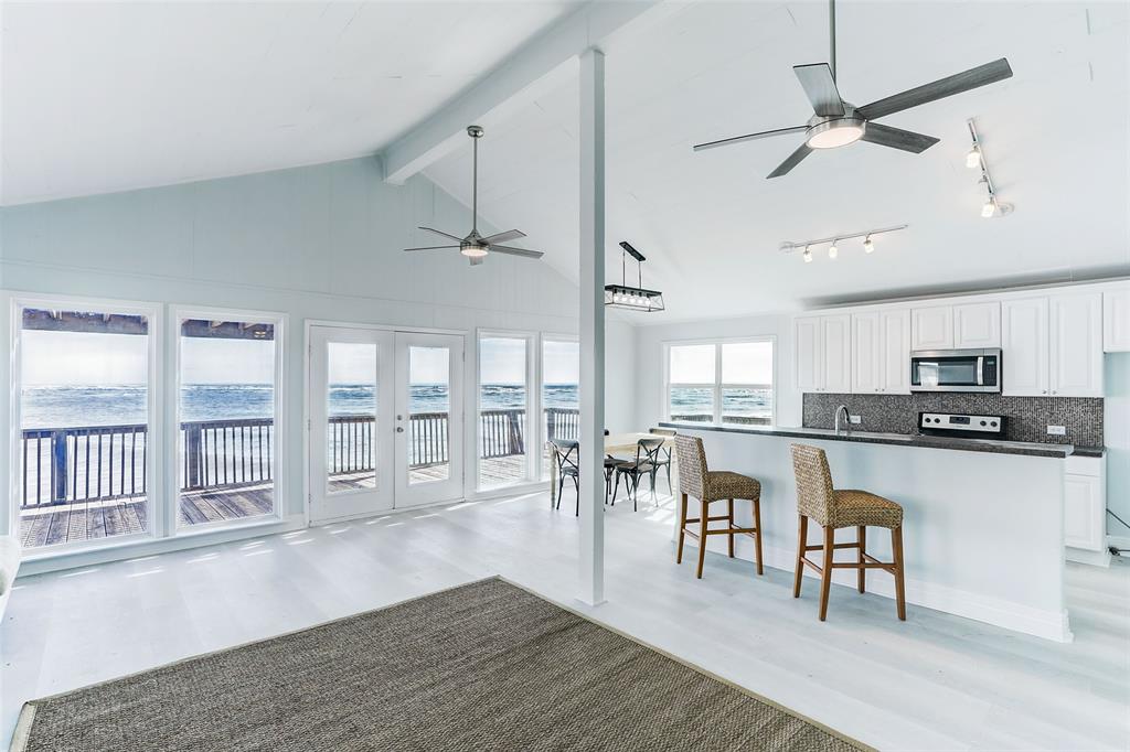 A VIEW OF THE LIGHT AND BRIGHT  KITCHEN AND BREAKFAST AREA FROM THE FAMILY SHOWING THE BREATHTAKING GULF VIEW.