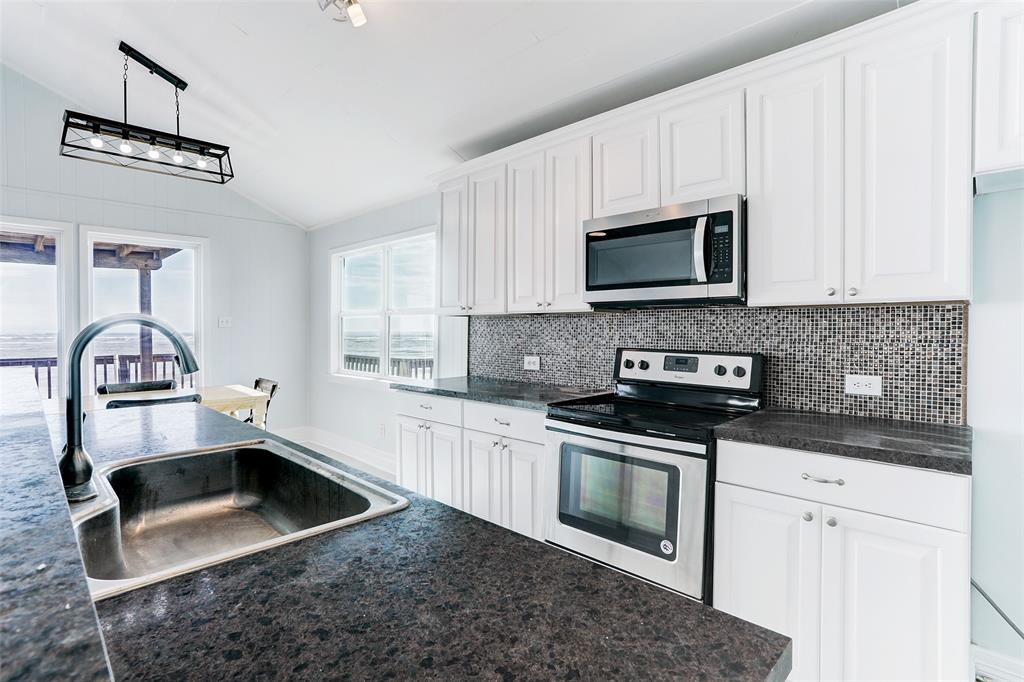 KITCHEN IS FRESH AND BRIGHT WITH WHITE CABINETS AND GORGEOUS COUNTERS.