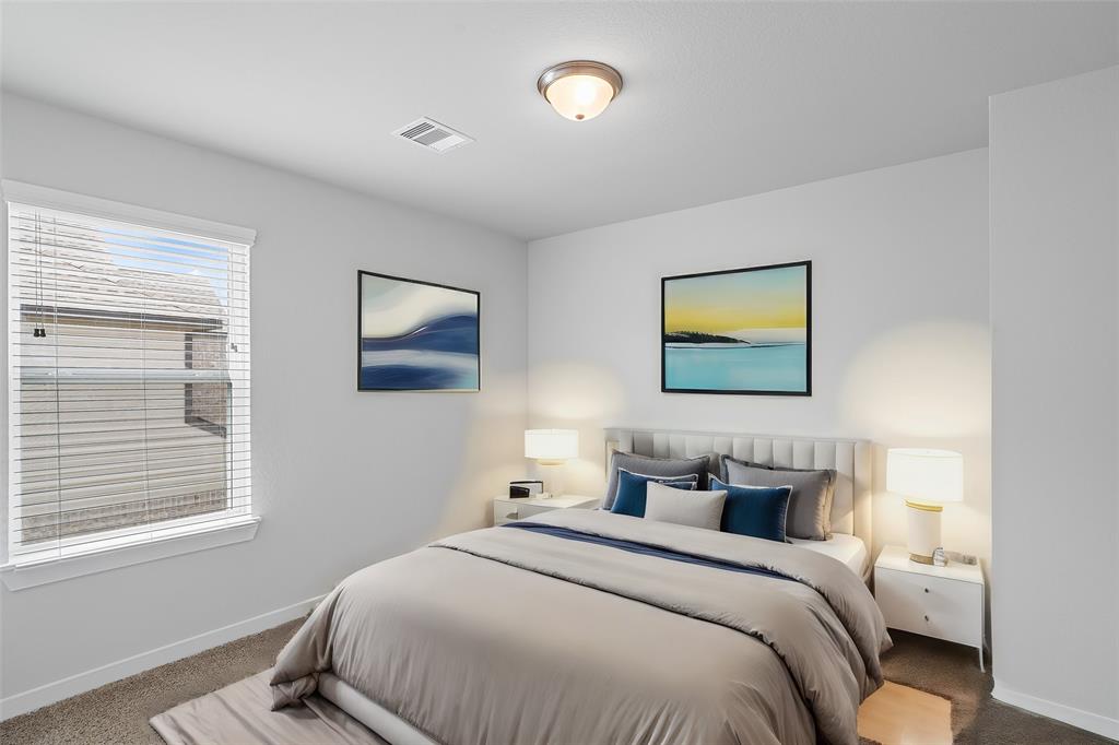 Secondary bedroom features plush carpet, custom paint and a large window with privacy blinds.