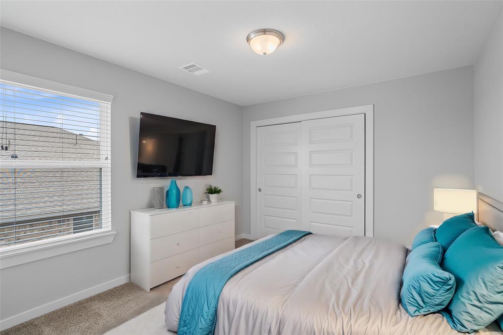 Secondary bedroom features plush carpet, custom paint and a large window with privacy blinds.