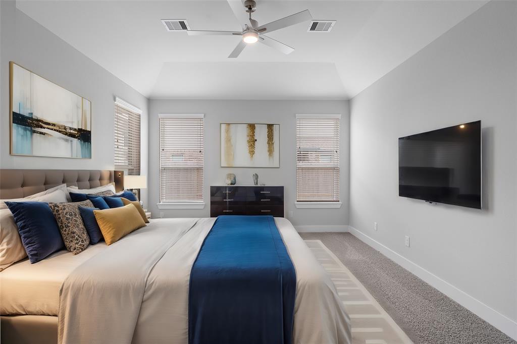 What a wonderful place to come home to, this stunning primary suite greets you with plush carpet, a neutral custom paint, high ceiling, ceiling fan with lighting, large windows with blinds allowing in natural light brightening up this spacious primary bedroom.