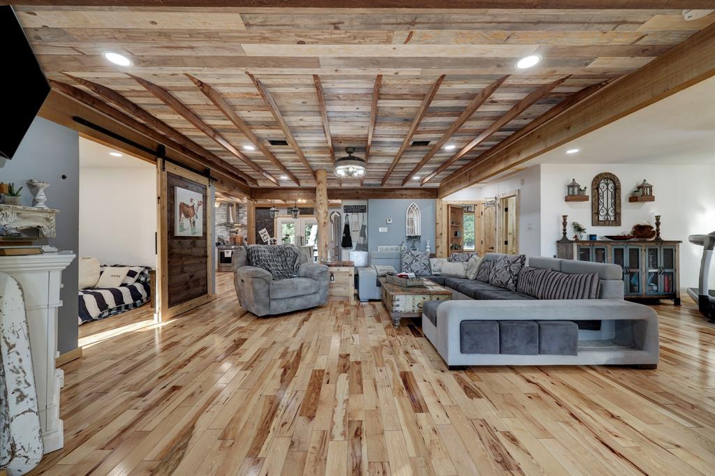 BEAUTIFUL! Notice the Custom floors and ceiling. This entire home was updated and customized. Wood boards, doors, ceilings, light fixtures, beams, casing, built ins and so much more. To the Left is a sliding barn door that lead to the junior en suite which offers a full bathroom attached to it.