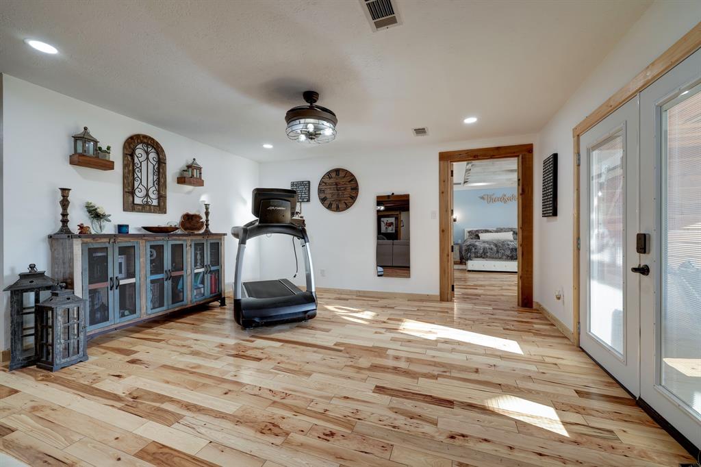 The Dining Room has open views into the Living Room, French doors leading to the front patio. High ceilings, recessed lighting, beautiful light fixture and wood flooring throughout. Tuck in the corner is the Owners retreat.