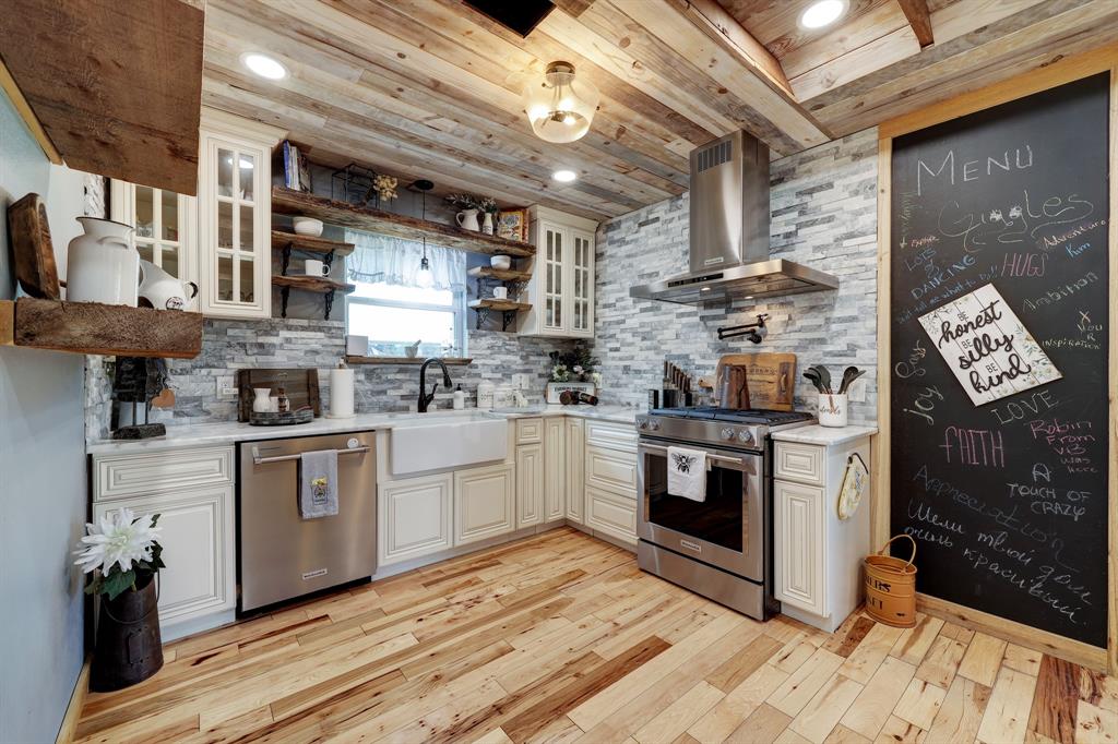 Tons of cabinet space! The off white cabinetry compliments the white quartz counter tops and the upgraded tiled backsplash. Notice the high end appliances and pot filler at the gas stove.  Pantry offers extra storage for convenience.