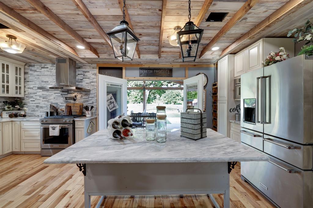 This view from the kitchen breakfast bar is perfect! One is able to join in with the Family room activities plus also enjoy the backyard views too. Another bonus is the counter makes a great serving space from Kitchen to Family room or a great prep work space. Million Dollar views into the green pastures.