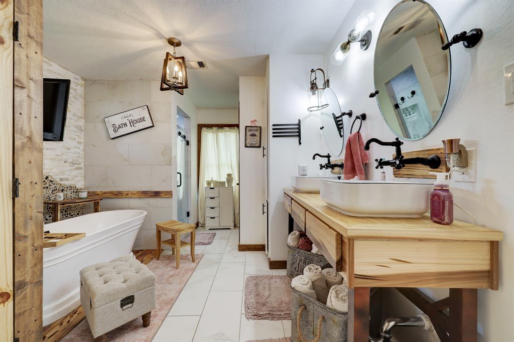 Lead into the Primary Spa-like Bathroom offering a luxurious tub, a roomy glass tiled shower, double sinks with tons of counter and cabinet space. Also offers a utility room with a set up for a full size washer and dry set and wardrobe closet.