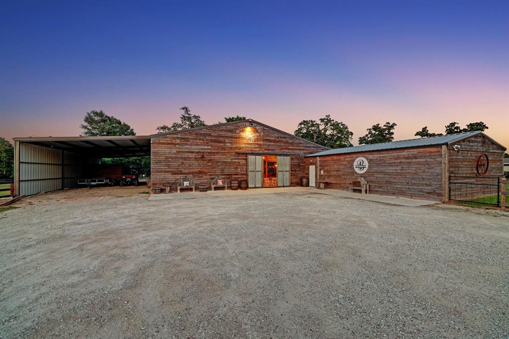 The carport to the left offers access to the kitchen, great for catering and delivery. The barn door can fit a vehicle or horse and carriage through.  The Building to the right is storage and offers an office.