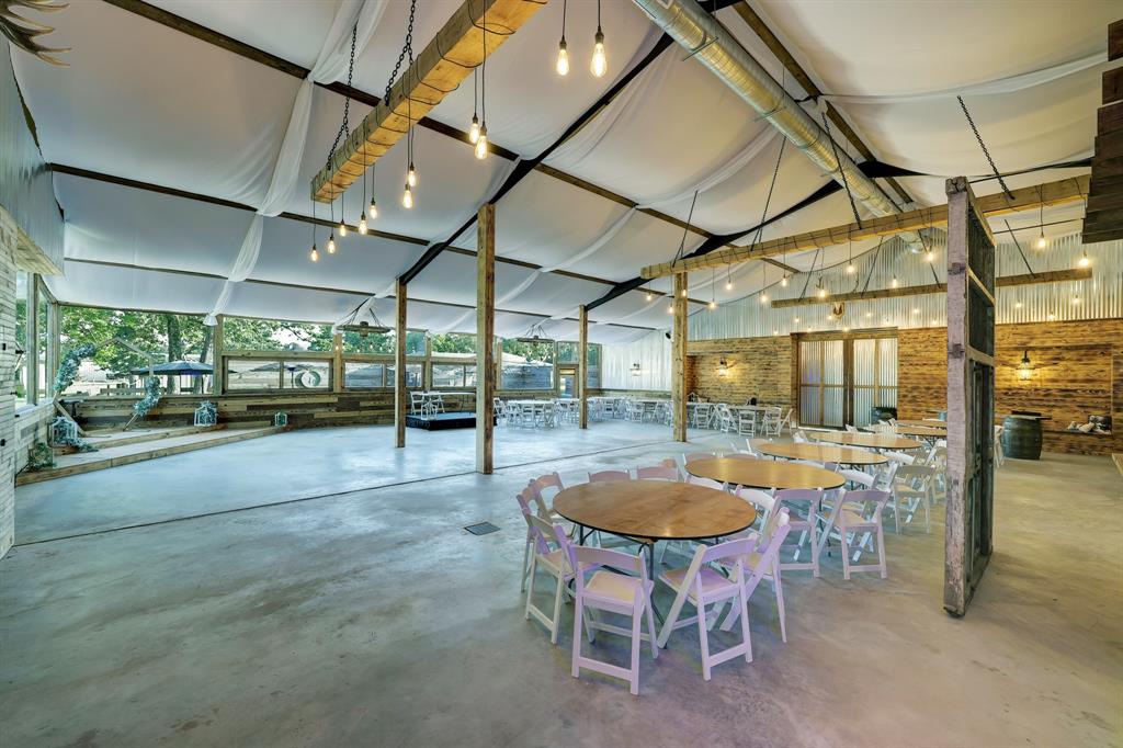 This one of a kind Rustic Barn Venus is so well planned. It is like no other place in the world! Notice the wall of windows for indoor and outdoor celebrations. To the right are antiques from the 1800\'s jail and the custom hanging wagon wheel lights.