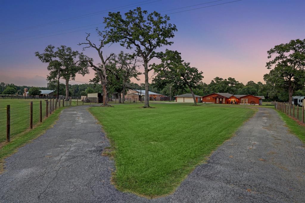 Large circle drive way to the main house. Mature trees and lush green space.