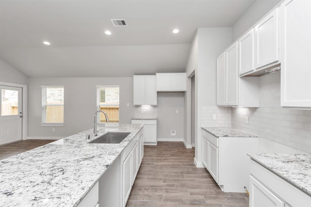 Discover another perspective of this stunning kitchen, generously appointed with an abundance of counter space