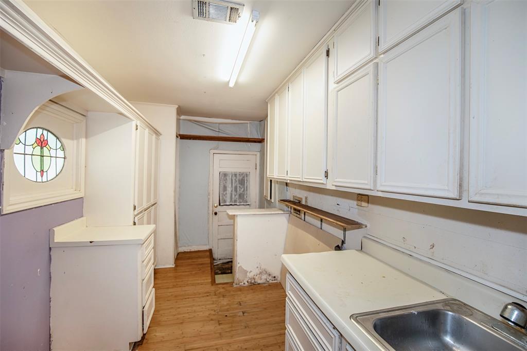 The utility room is located near the front door and has ample cabinet space.