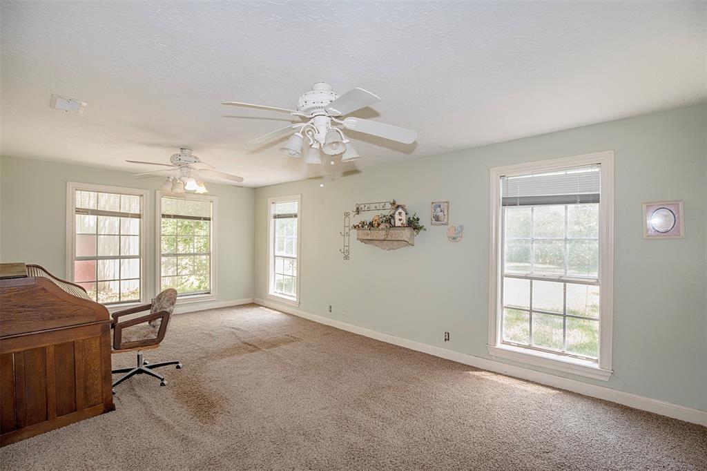 This spacious secondary bedroom has tall windows.