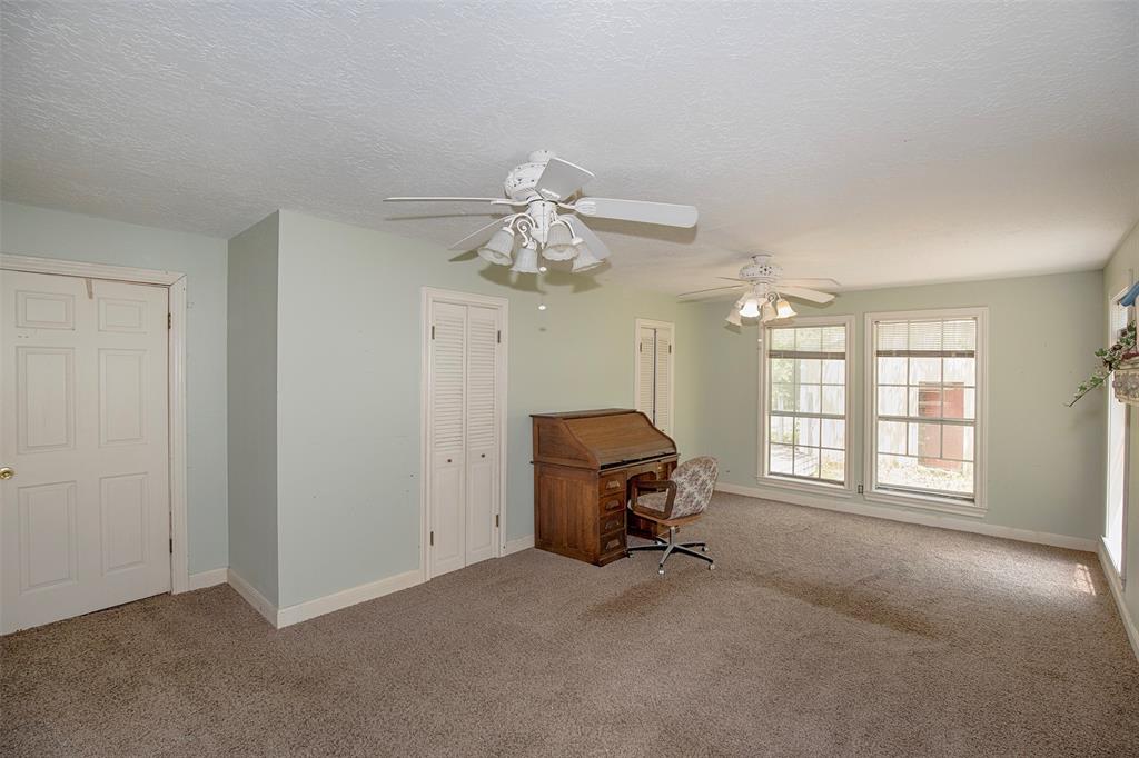 Another view of the bedroom that boasts two ceiling fans.