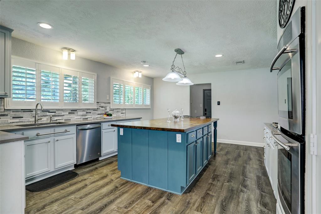 Chef\'s kitchen! Butcher block counter top island, energy efficient windows adorned by custom blinds looks out to side yard