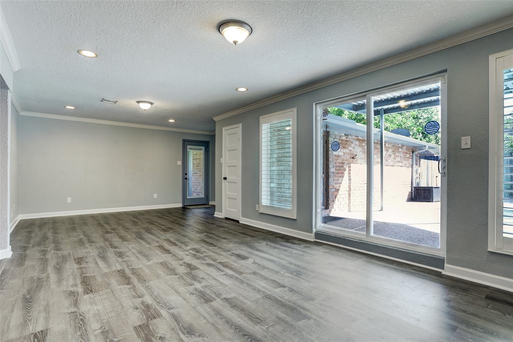 Vacant game room has a door that leads out to the breezeway and detached garage