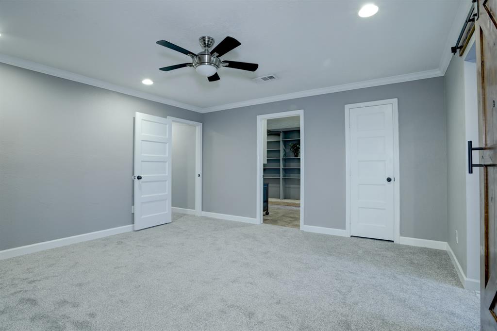 View of primary to hall and office that sits off of the bedroom and includes a walk-in closet, crown molding and ceiling fan- 14x14