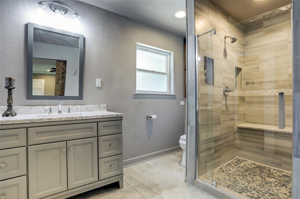 Gorgeous primary bath with luxurious stand up seated shower. Walk-in closet to the left of sink