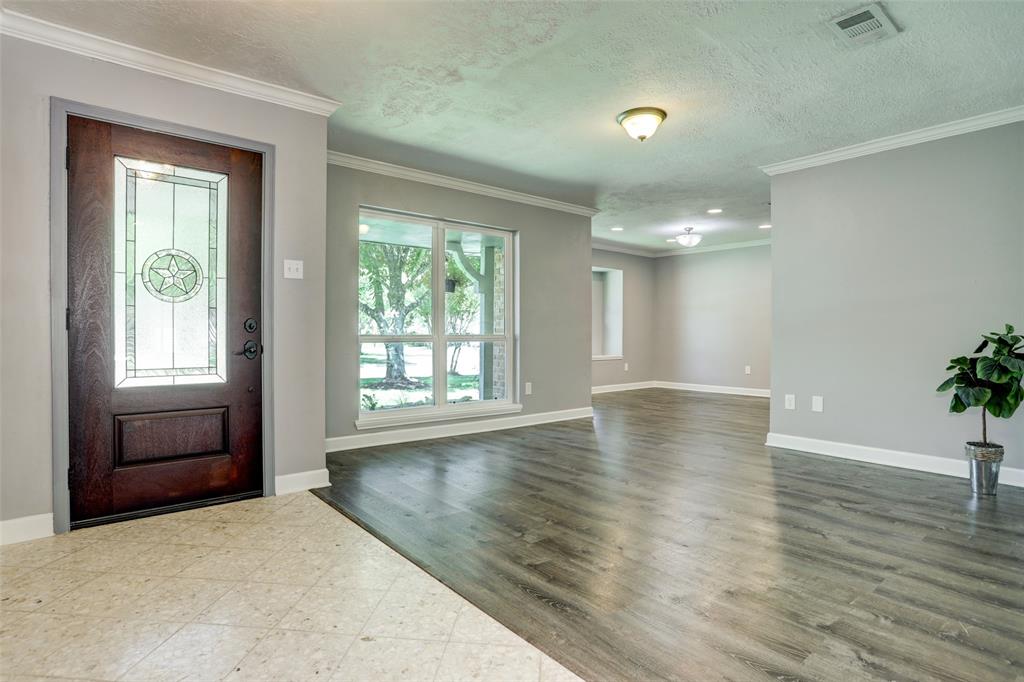 Grand foyer with marble tile, Vacant view of formal living and dining off of kitchen. Luxury vinyl flooring, upgraded energy efficient windows and crown molding