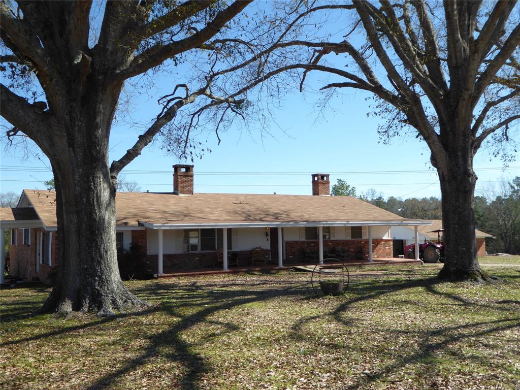 All Brick Home is on 1 Acre & Includes Adjoining 9 acres.  Per Seller: Property Encompasses approximately 10,000 sq ft Barn, 2400 sq ft Shop, Fenced In Pasture, 3 Car Garage, Concrete Pit-Change Oil & More! With TLC, this Home will be Your Perfect Country Home. Enjoy the Beautiful Sunsets Lounging on the Front Porch Across the Front of Home. Spacious Living-Dining Area has Immense Wood Burning Fireplace for Those Cold Evenings.  Retro Kitchen has a Large Walk In Pantry & Lots of Counter Space & Cabinets. Primary Bedroom has a Cozy, Wood Burning Fireplace w/Room for Your Comfy Chairs, Small Kitchenette, Spacious Bedroom w/In Suite Bath & Walk In Closet.  Guest Bedroom Makes a Great Mother-In-Law Suite with In Suite Bath. New Water Heater in Primary Bath 2023 & Recent Water Heater in Kitchen 2022; Recent Roof 2022. Per Seller: Three Phase Power available & There is a Creek Across the Back of Property with an 1/4 Acre Pond.  Enjoy the Country & Have  Buildings & Space  for Your Business.