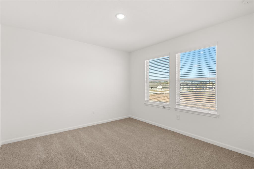 Your secondary bedroom features plush carpet, fresh paint, closet, and a large window that lets in plenty of natural lighting.