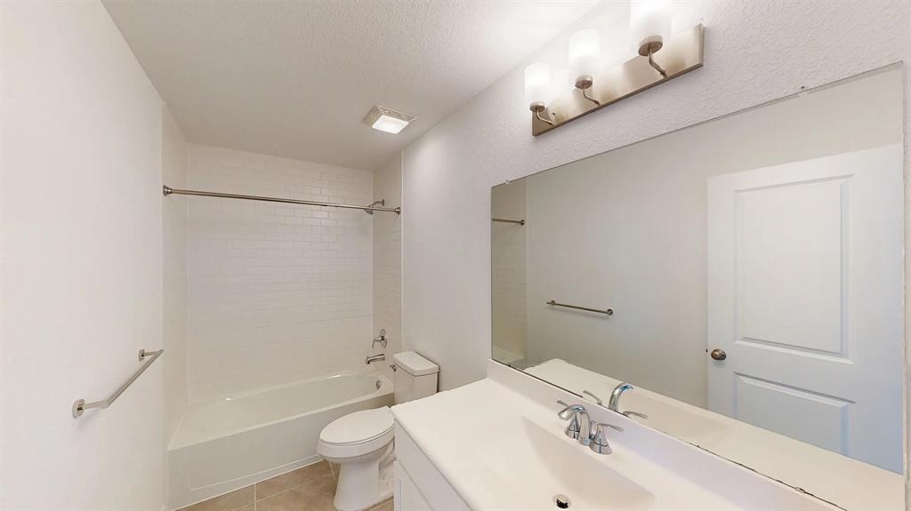 The secondary bath features tile flooring, white cabinetry and light countertops and a shower/tub combo. Perfect for accommodating any visiting family and friends.