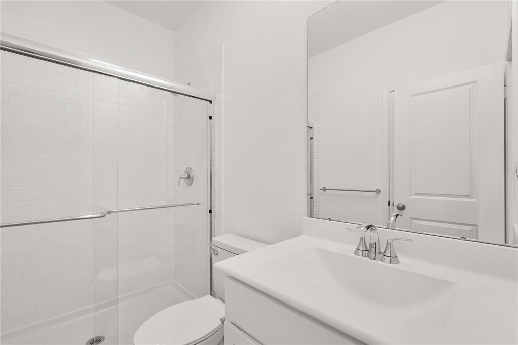 The secondary bath features tile flooring, white cabinetry and light countertops and a large walk-in shower. Perfect for accommodating any visiting family and friends.